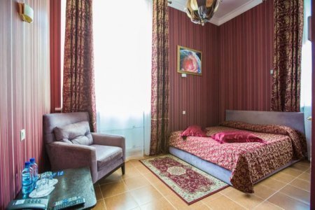 Кровать номера  Делюкс в отеле Зодиак