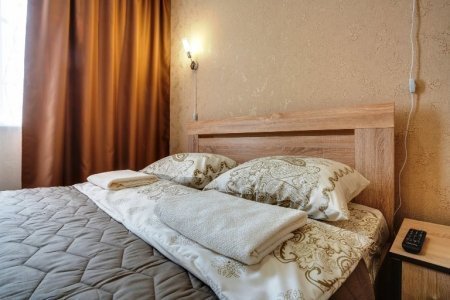 Кровать в номере Полулюкс в отеле Ладомир на Щелковской