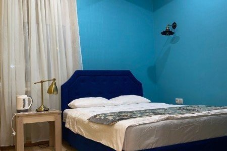 Кровать в номере Стандарт с душем в отеле Апельсин на Вернадского