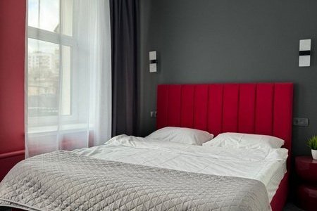 Кровать в номере Комфорт Премиум красный в отеле Гости на Белорусской