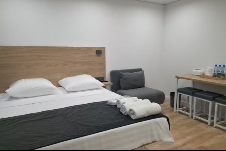 Двуспальная кровать в номере Комфорт трехместный №5 в отеле Buta Hotel 4