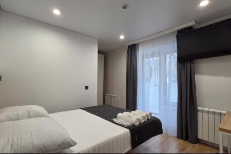 Двуспальная кровать в номере Стандарт №8 в гостинице Buta Hotel 4