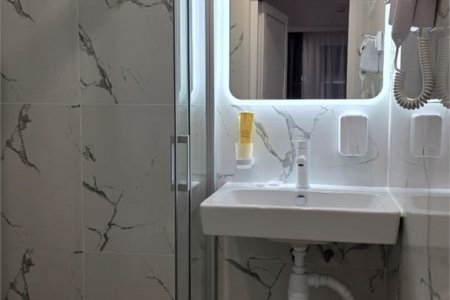 Раковина с зеркалом в номере Комфорт №4 в отеле Buta Hotel 4