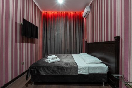 Кровать у окна в номере 9 Делюкс в отеле De Art на Тверской